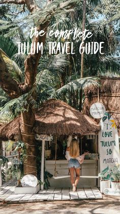 a woman standing in front of a palm tree with the words, the complete tulum travel guide