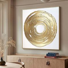 a dining room table with chairs and a painting on the wall above it that has gold foiled circles