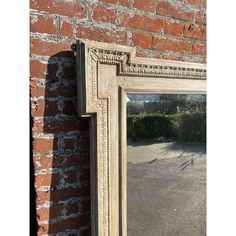 an old mirror hanging on the side of a brick wall