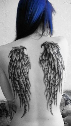 the back of a woman with blue hair and wings tattoo on her upper half body