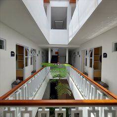 the inside of a building with white walls and wooden balconies on each floor