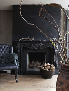 a living room with a fire place and chairs