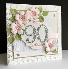 a white card with pink flowers and the number 90 on it's side, in front of a black background