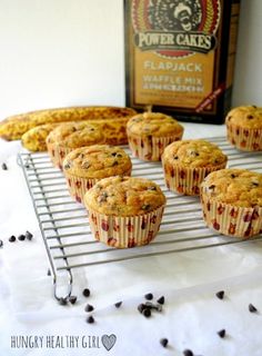 muffins cooling on a wire rack next to a bottle of rum and chocolate chips