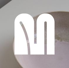 a close up of a bowl on a table with the letter m in it's center