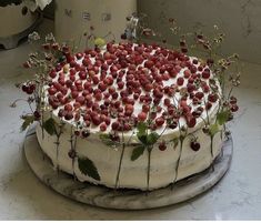 a cake with white frosting and strawberries on top is sitting on a table