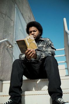 a man sitting on the steps reading a book