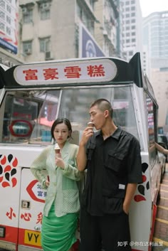 a man and woman standing in front of a food truck