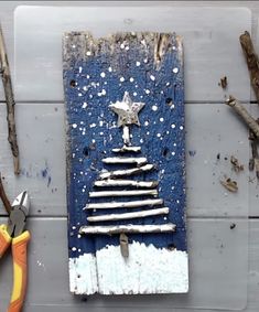 a christmas tree made out of wood with pliers and branches around it on a wall