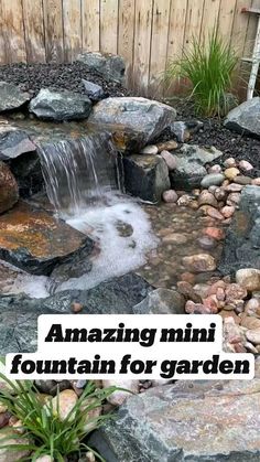 a small garden with rocks and water flowing from it's side to the ground