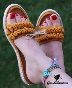 a woman's feet wearing crochet sandals and bracelets on her left foot