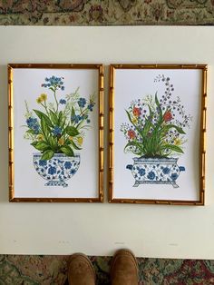 two framed pictures with flowers in them on a wall next to a pair of brown boots