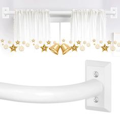 a white curtain with gold stars hanging from it's side and two bells on the top