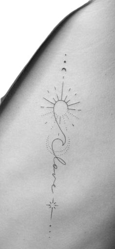 the back of a woman's stomach with a sun and stars tattoo on it