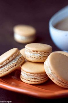 a plate with some cookies on it and a cup of coffee in the back ground