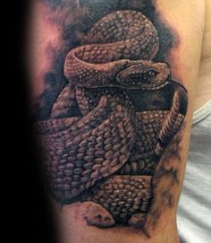 a man with a tattoo on his arm that has a snake wrapped around it