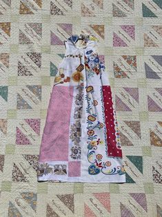 a dress made out of different fabrics on a quilt