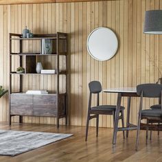 a dining room with wood paneled walls and wooden flooring, along with two chairs and a table