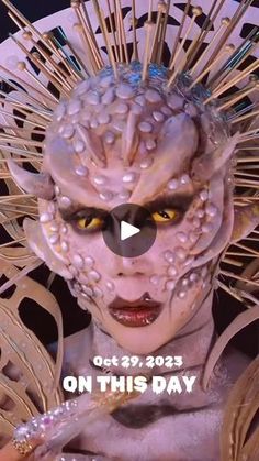 a woman with white makeup and elaborate headdress on her face is featured in the video