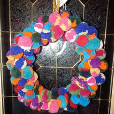 a multicolored wreath hanging on the front door with a mirror in the background