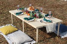 a table set up with plates, glasses and napkins for an outdoor dinner party