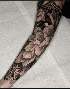 a black and white flower tattoo on the arm, done by an expert in body art