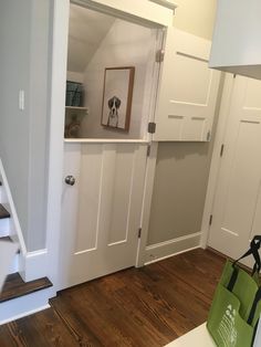 the interior of a house with white walls and wood flooring, including an open door