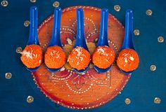 five blue spoons with orange balls on them