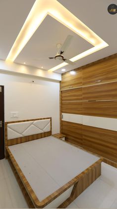 a bed room with a neatly made bed and a ceiling fan on the wall above it