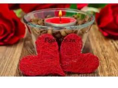 two red heart shaped candles sitting on top of a table