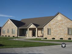 a large brick house sitting on top of a lush green field in front of a blue sky