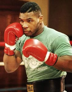 a man in green shirt and red boxing gloves