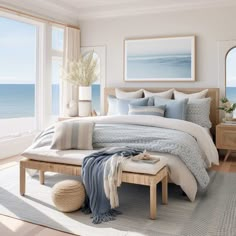 a bedroom with a large window and a bed in front of an ocean side view