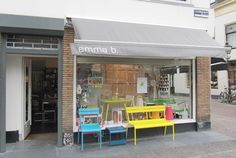 two colorful chairs sitting in front of a store