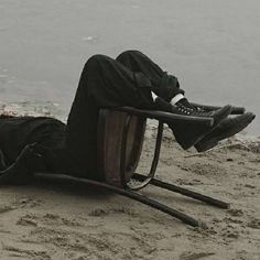 a man sitting in a chair on the beach