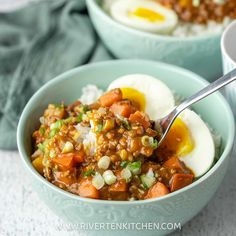 two bowls filled with rice and vegetables next to an open hard boiled egg on top