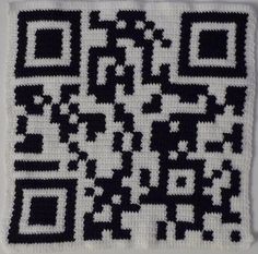 a black and white crocheted square with qr code on it