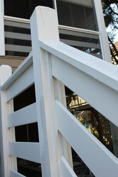 a close up of a white fence with a house in the background