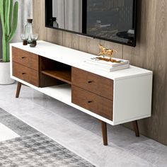 a white and brown entertainment center in a living room with cactus on the sideboard