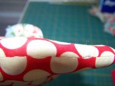 a close up of a red and white polka dot print cloth on a sewing machine