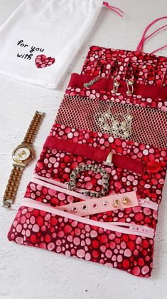 several pieces of fabric are laid out on the floor next to a watch and bracelet