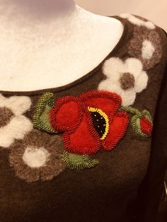 a brown sweater with red flowers on the front and white polka dots on the back