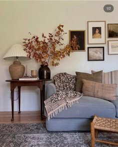 a living room with pictures on the wall and a couch in front of a coffee table