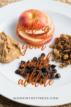 a white plate topped with granola, an apple and chocolate chips next to peanut butter