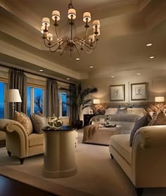 a living room filled with lots of furniture and a chandelier hanging from the ceiling