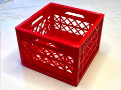 a red plastic crate sitting on top of a white table