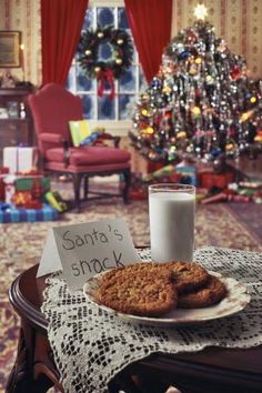 cookies and milk on a table in front of a christmas tree with santa's snack written on it