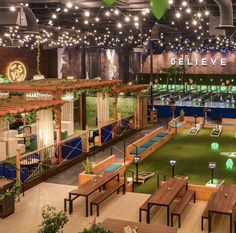 the inside of a restaurant with tables, benches and lights hanging from the ceiling above