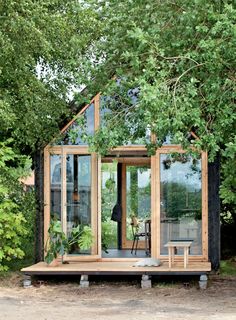 a small wooden house surrounded by trees and greenery