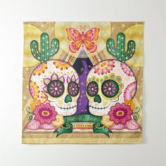 two sugar skulls with flowers and butterflies on their heads in front of a gold background